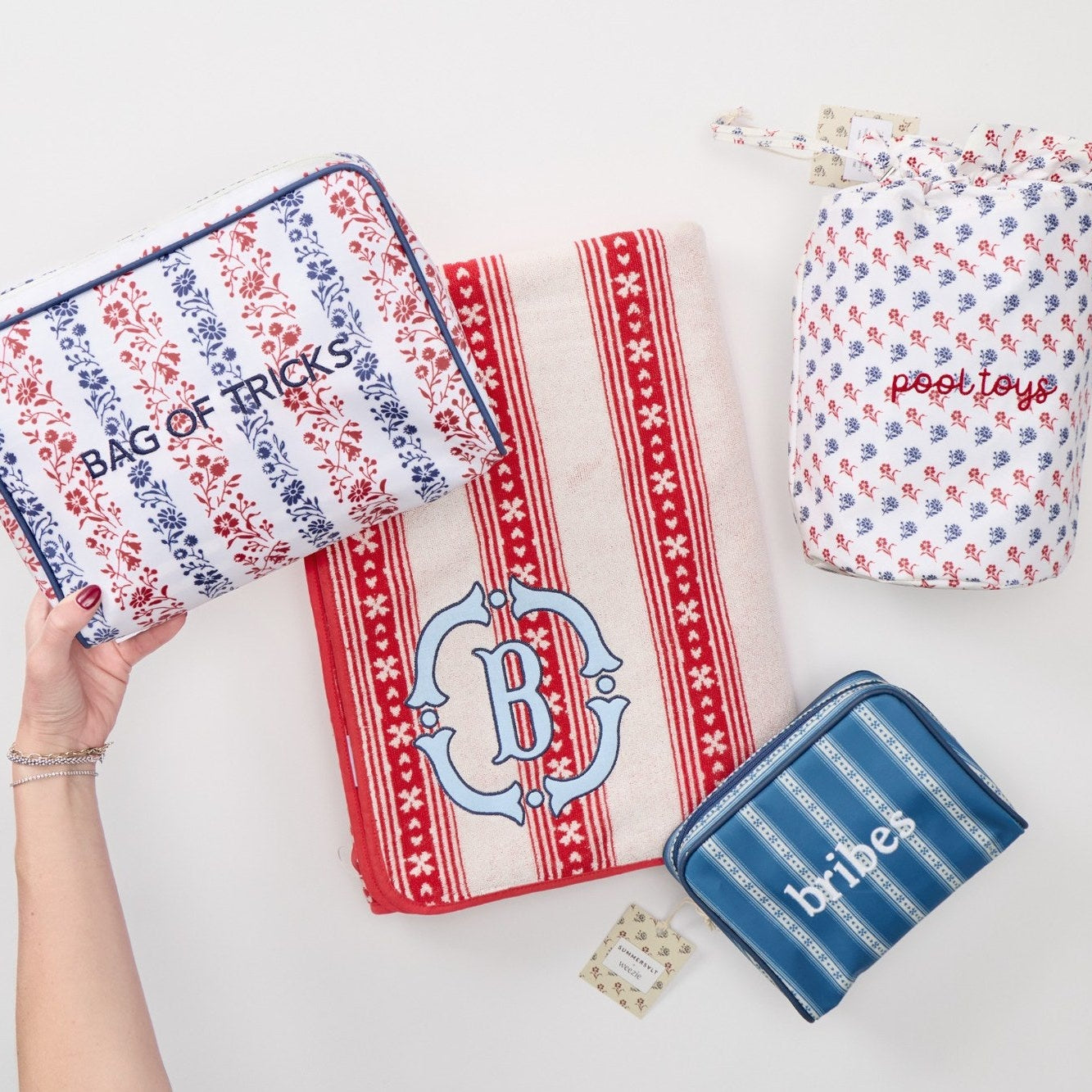 Collection of beach towels and bags with branding on a white background
