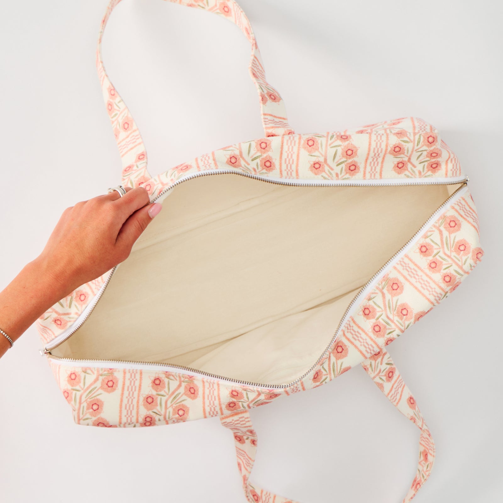 An open Mahjong bag featuring a peach and white climbing vine pattern, revealing a plain cream interior lining.