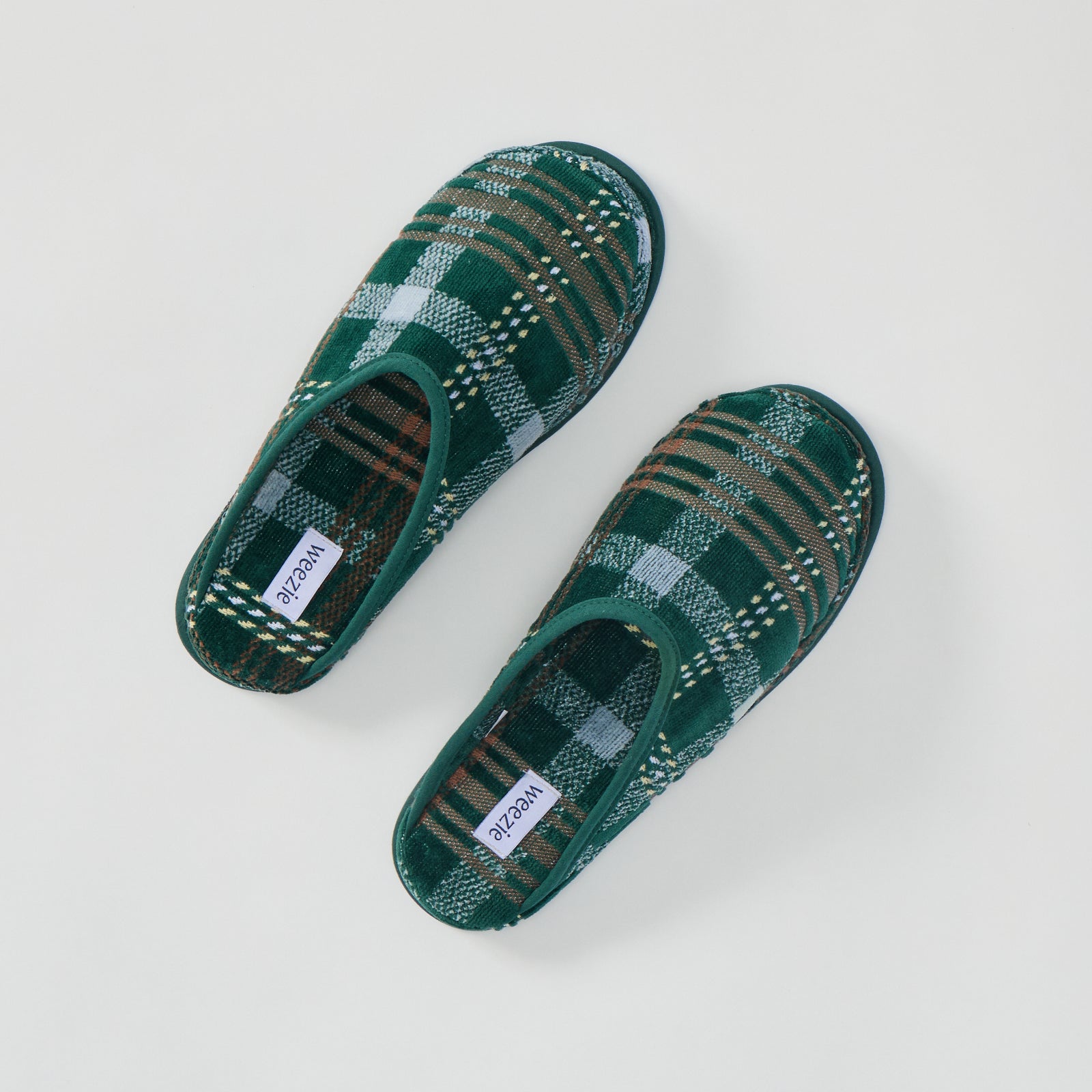 A pair of men's green plaid terry slippers shown from above.