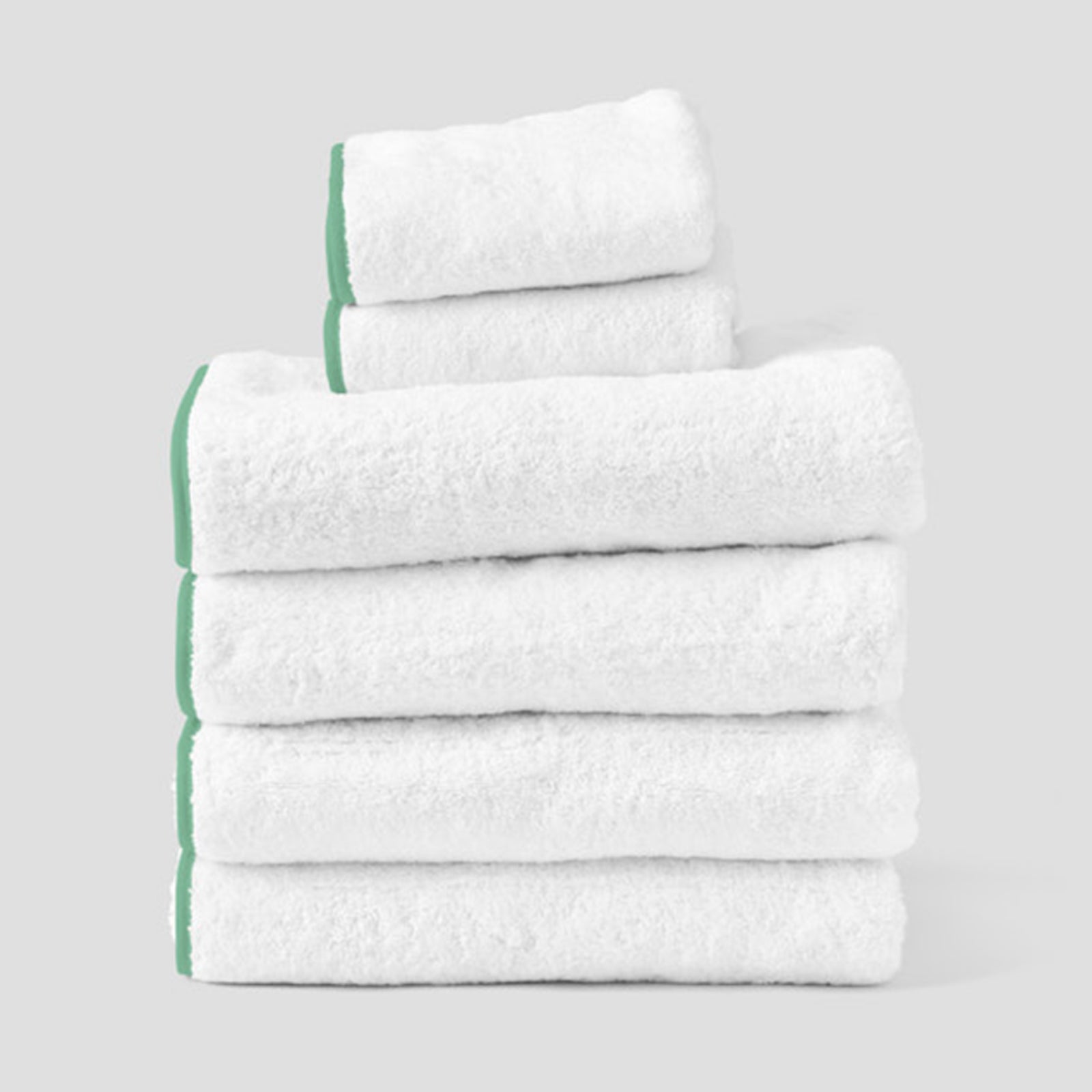 Signature Starter Pack in Green on White, a folded stack of white towels with green piping.