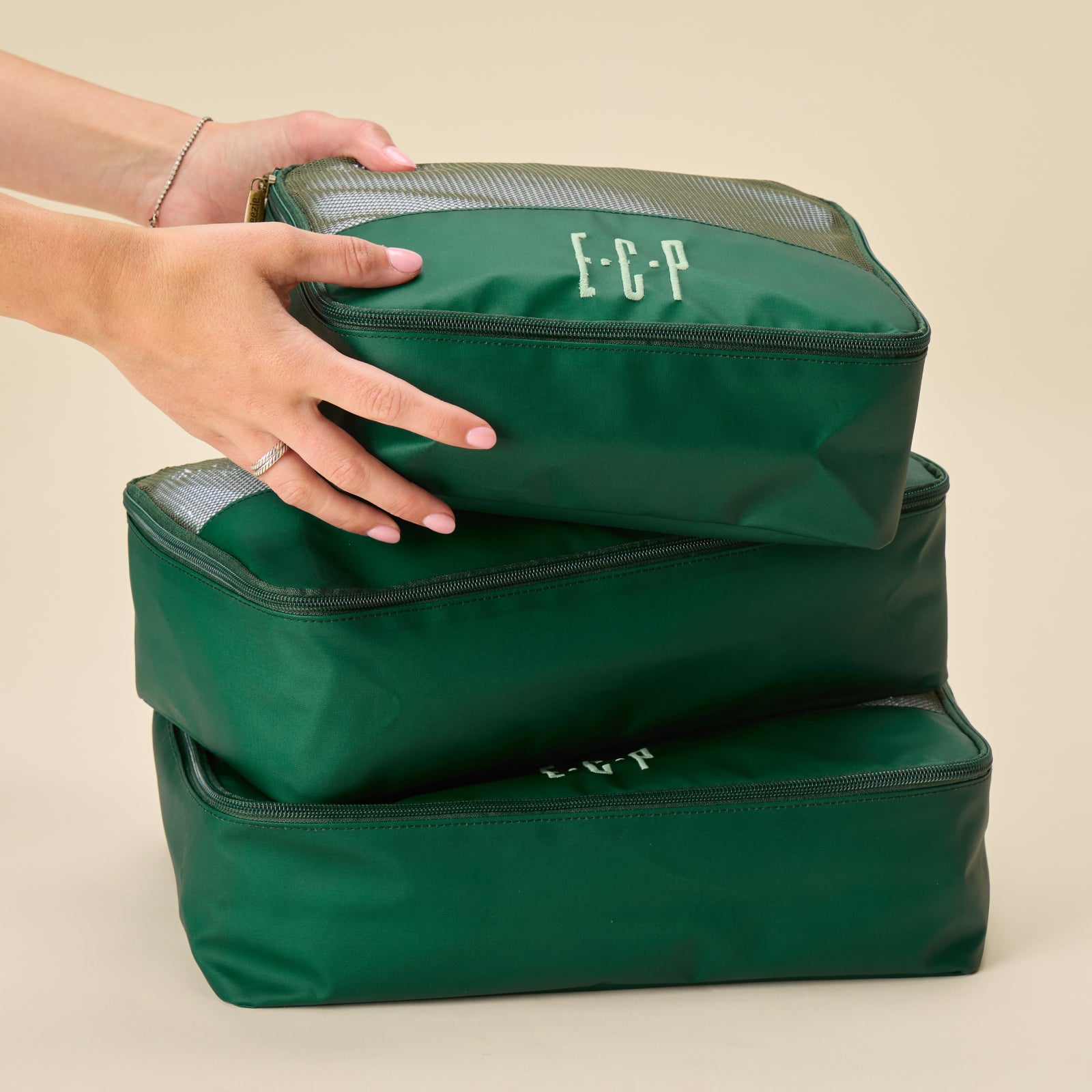 Packing cube bundle in solid green colorway featuring lightweight travel organizers with breathable mesh tops.