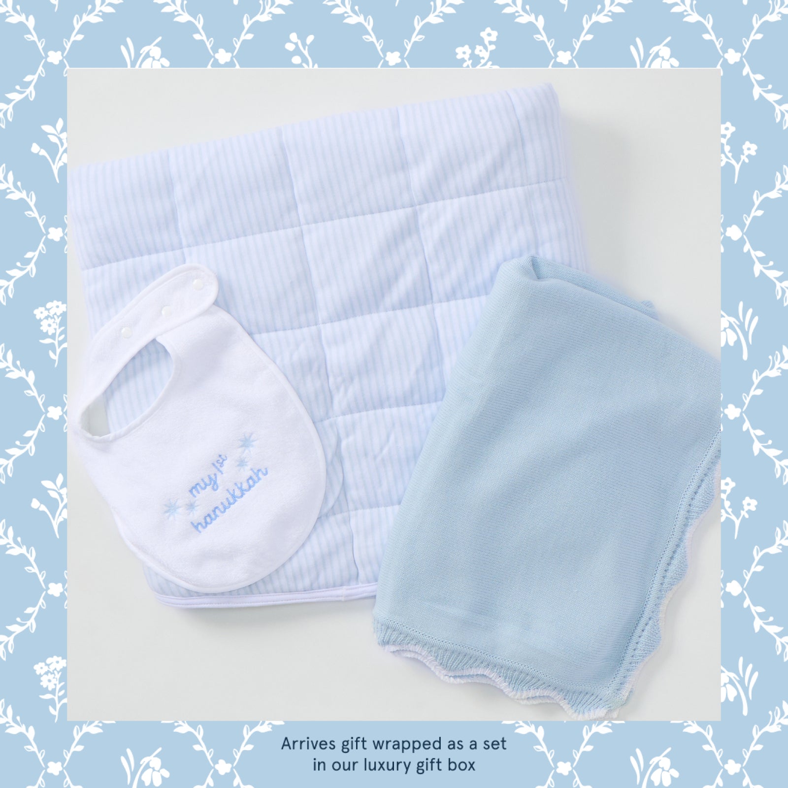 My First Hanukkah baby gift set in light blue, bib, knit blanket and striped tummy time mat laid flat