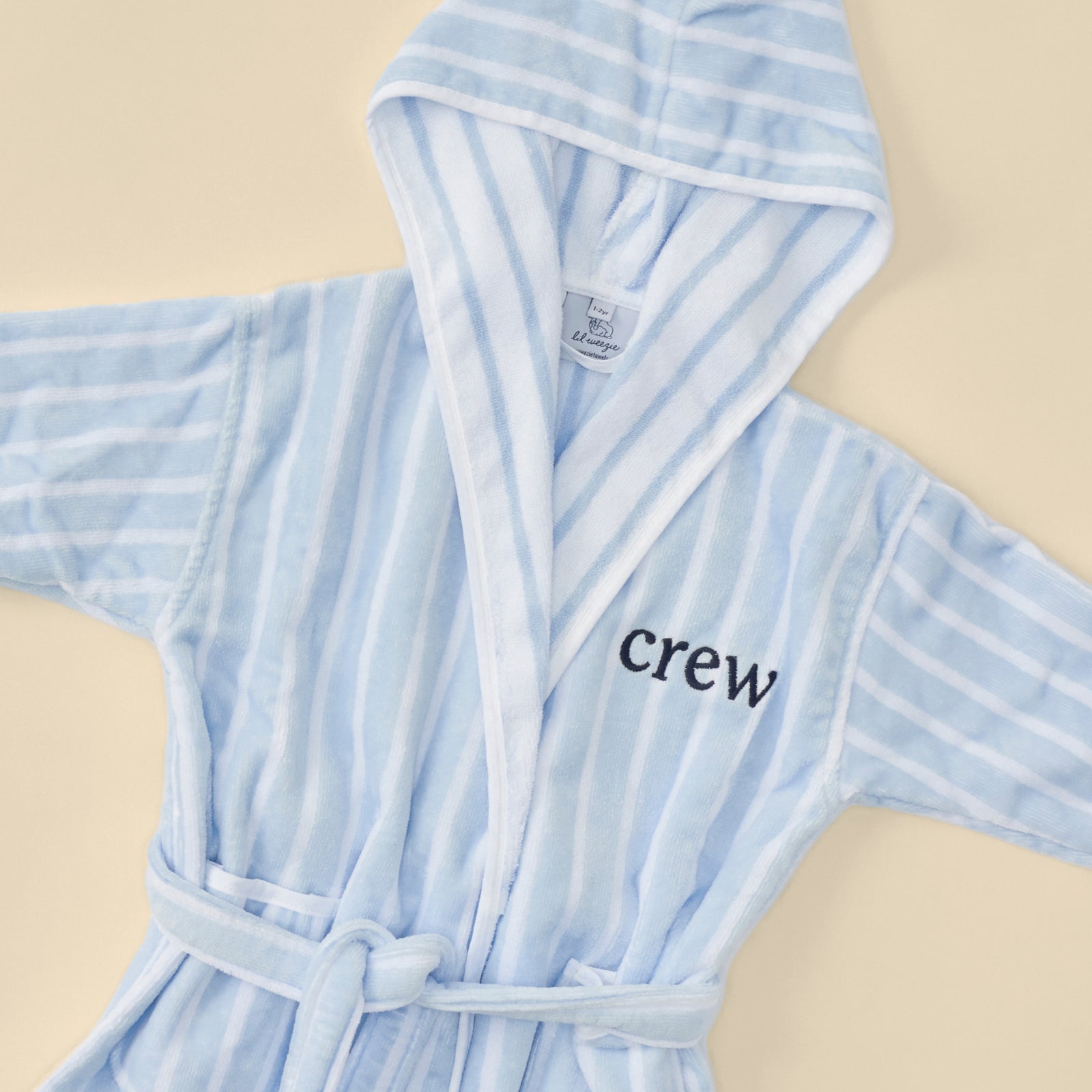 A fluffy light blue striped bathrobe with "crew" embroidery.