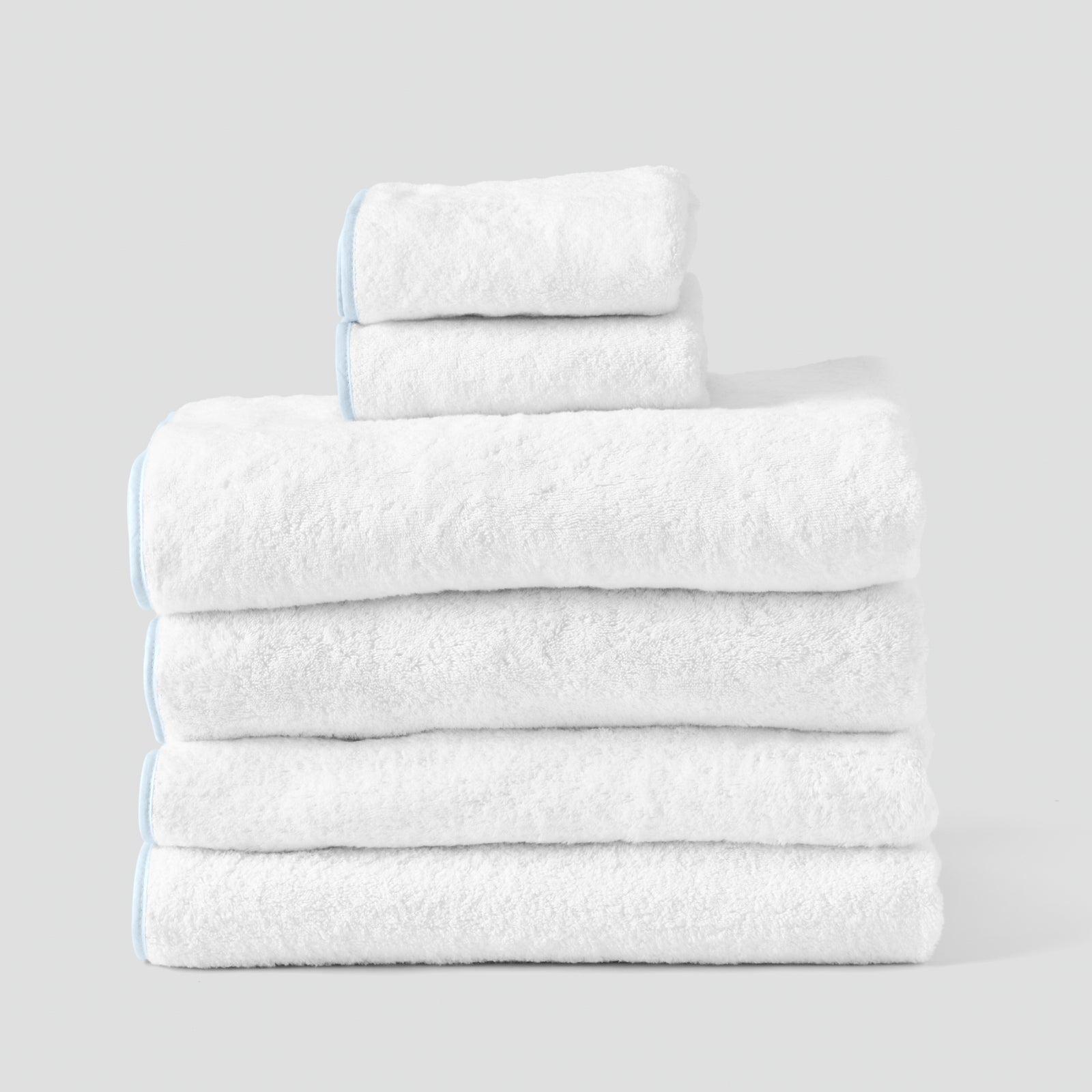 Bath Sheet Starter Pack in Light Blue on White, a folded stack of white towels with light blue piping.