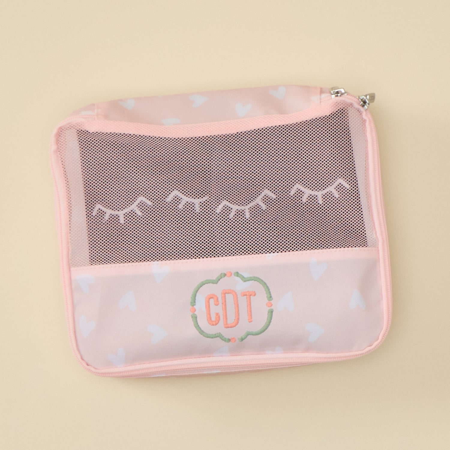 Small packing cube in light pink print with breathable mesh top for organized travel packing.
