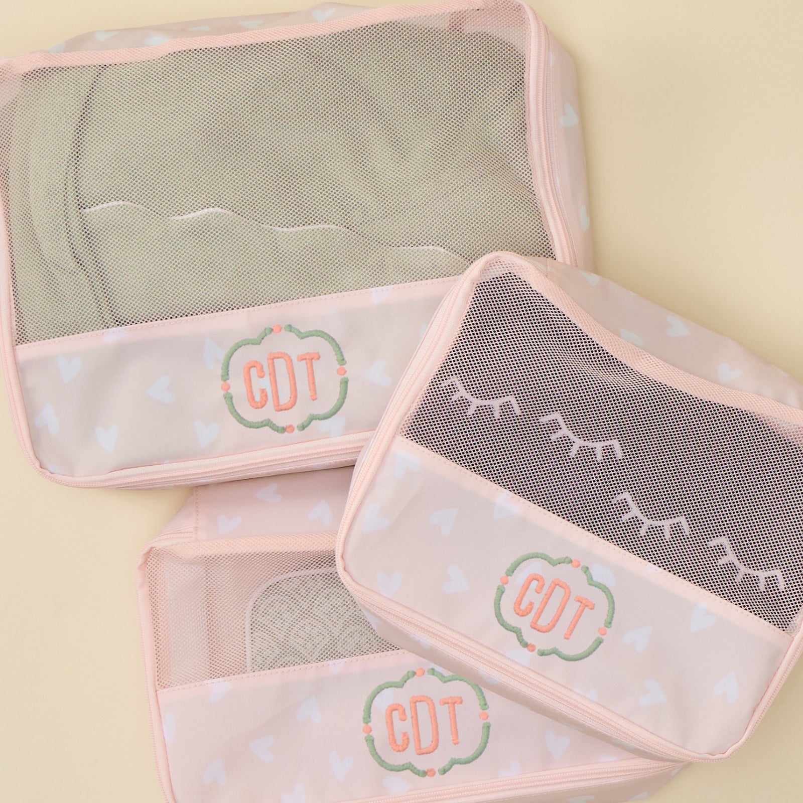Packing cube bundle in pink heart print featuring lightweight travel organizers with breathable mesh tops.