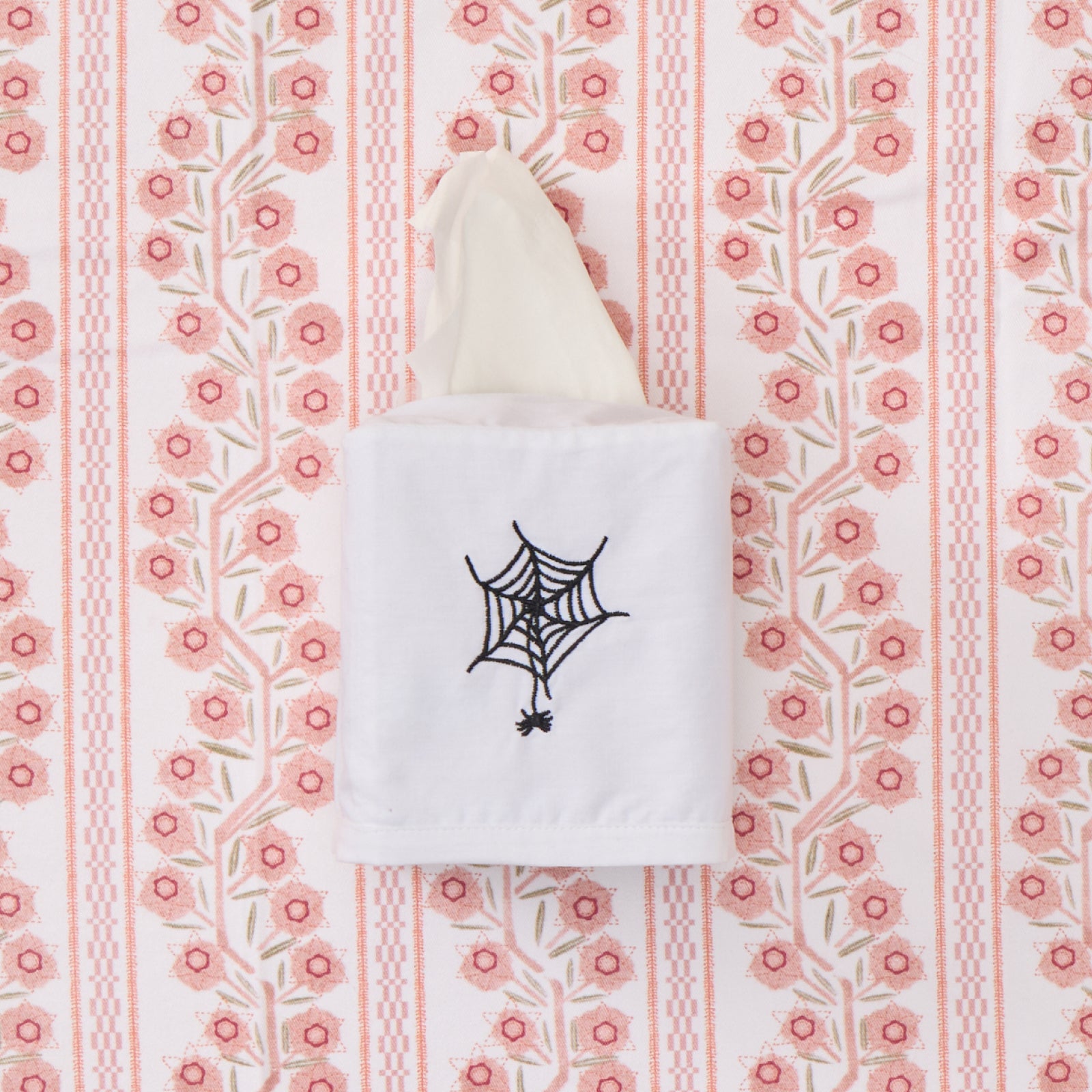 White cotton tissue box cover featuring black spider web embroidery.
