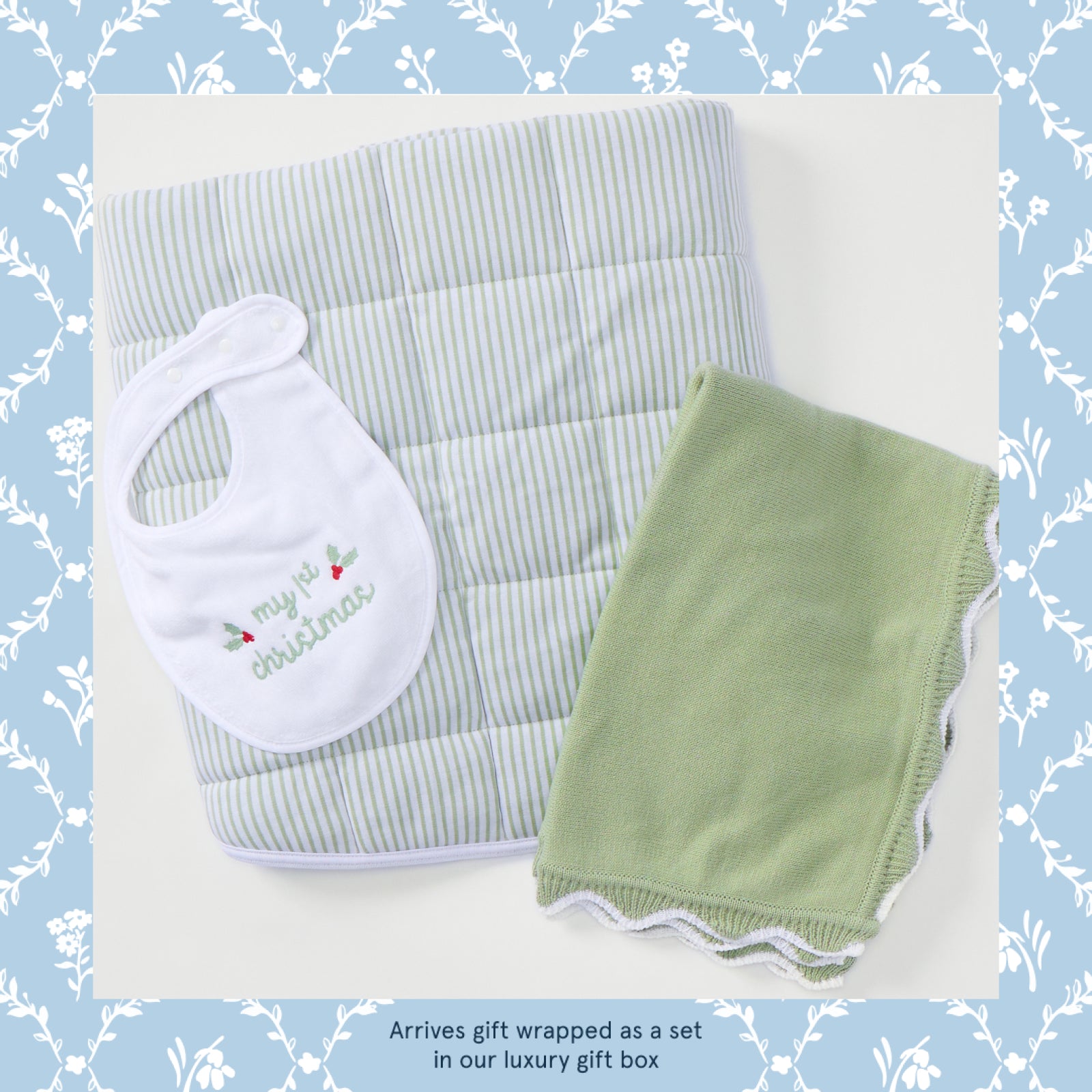 My First Christmas baby gift set in sage green, bib, knit blanket and striped tummy time mat laid flat