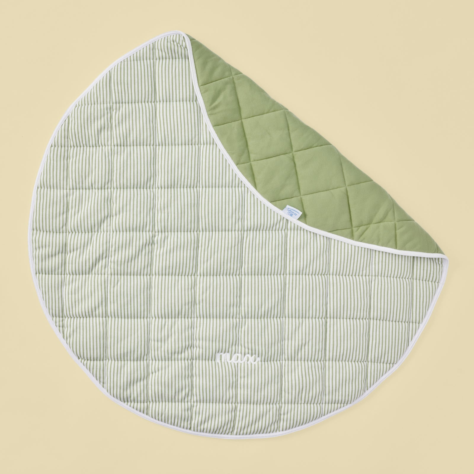 Green and white striped quilted baby mat featuring white max embroidery.