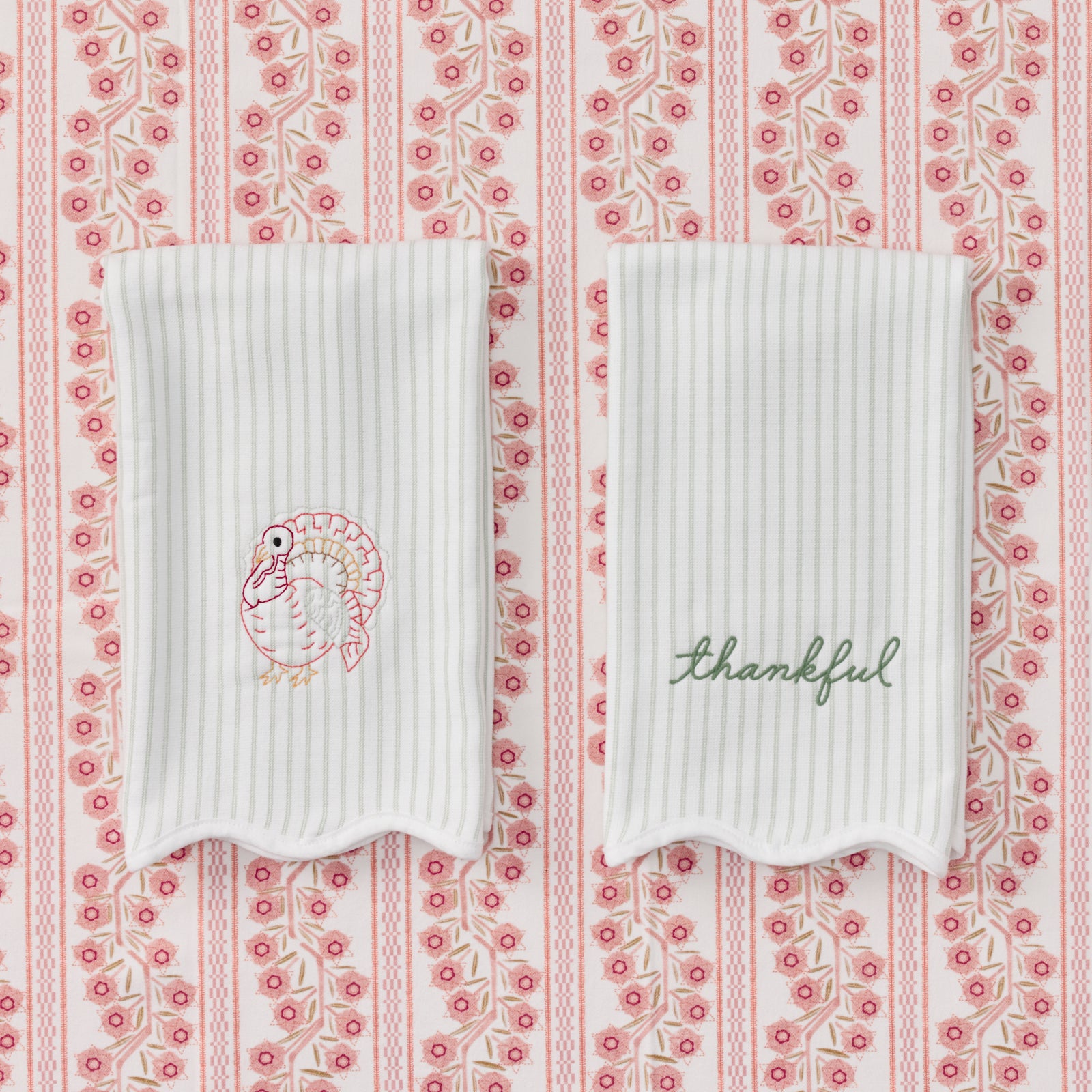 Pair of scalloped green striped kitchen towels featuring pink turkey and thankful embroidery.