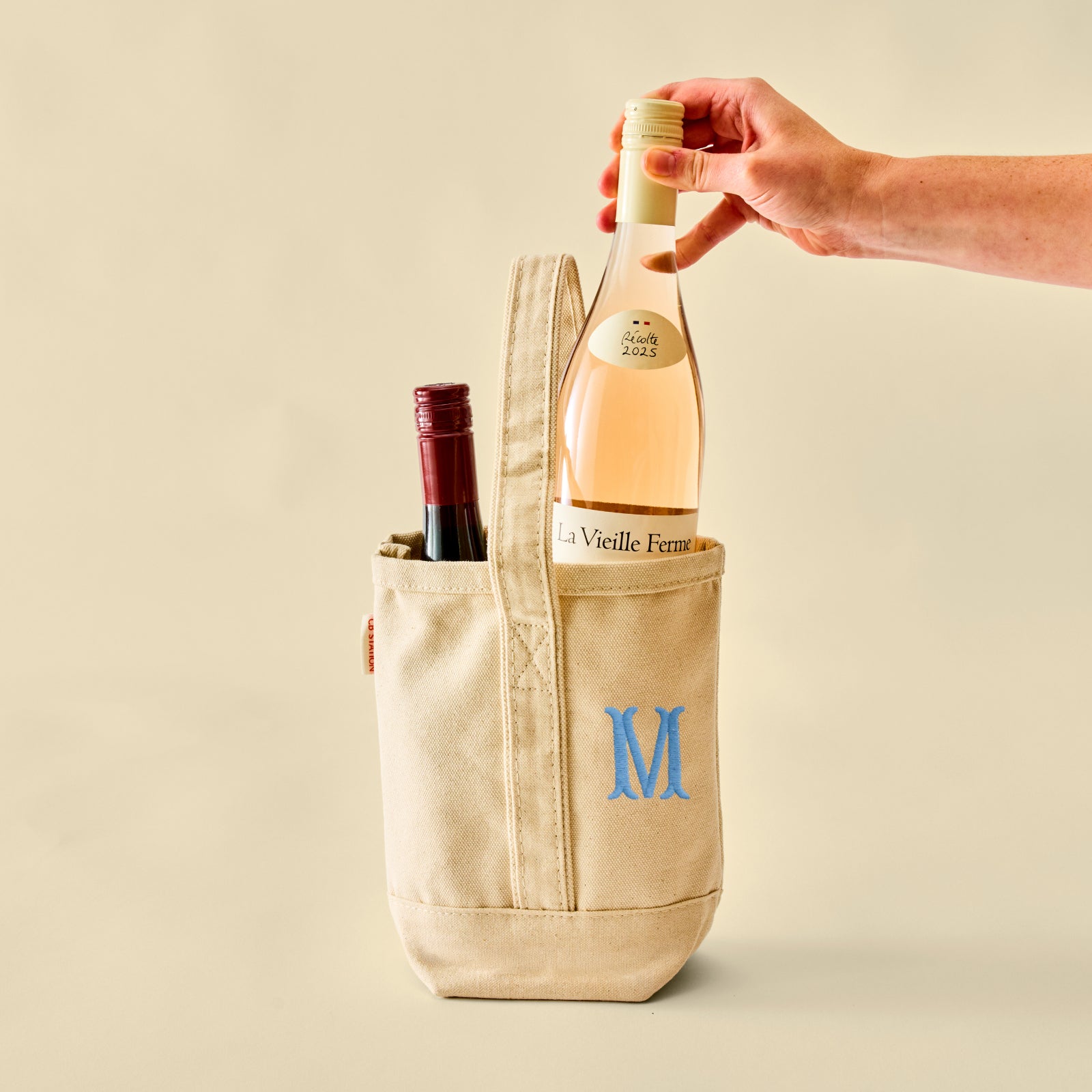 The Guest Ready Set in Twilight, canvas wine tote with a sample monogram holding two bottles