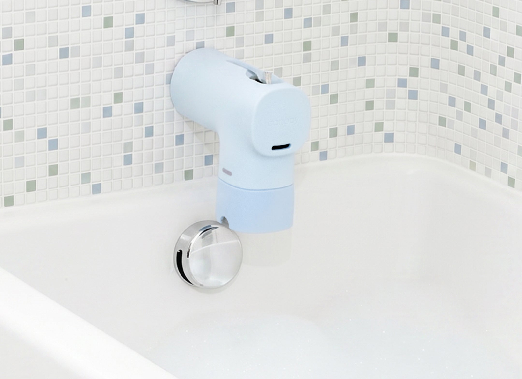 A light blue spout protector cover installed on a bathroom faucet above a white bathtub, with a tiled wall background and an informational text overlay.