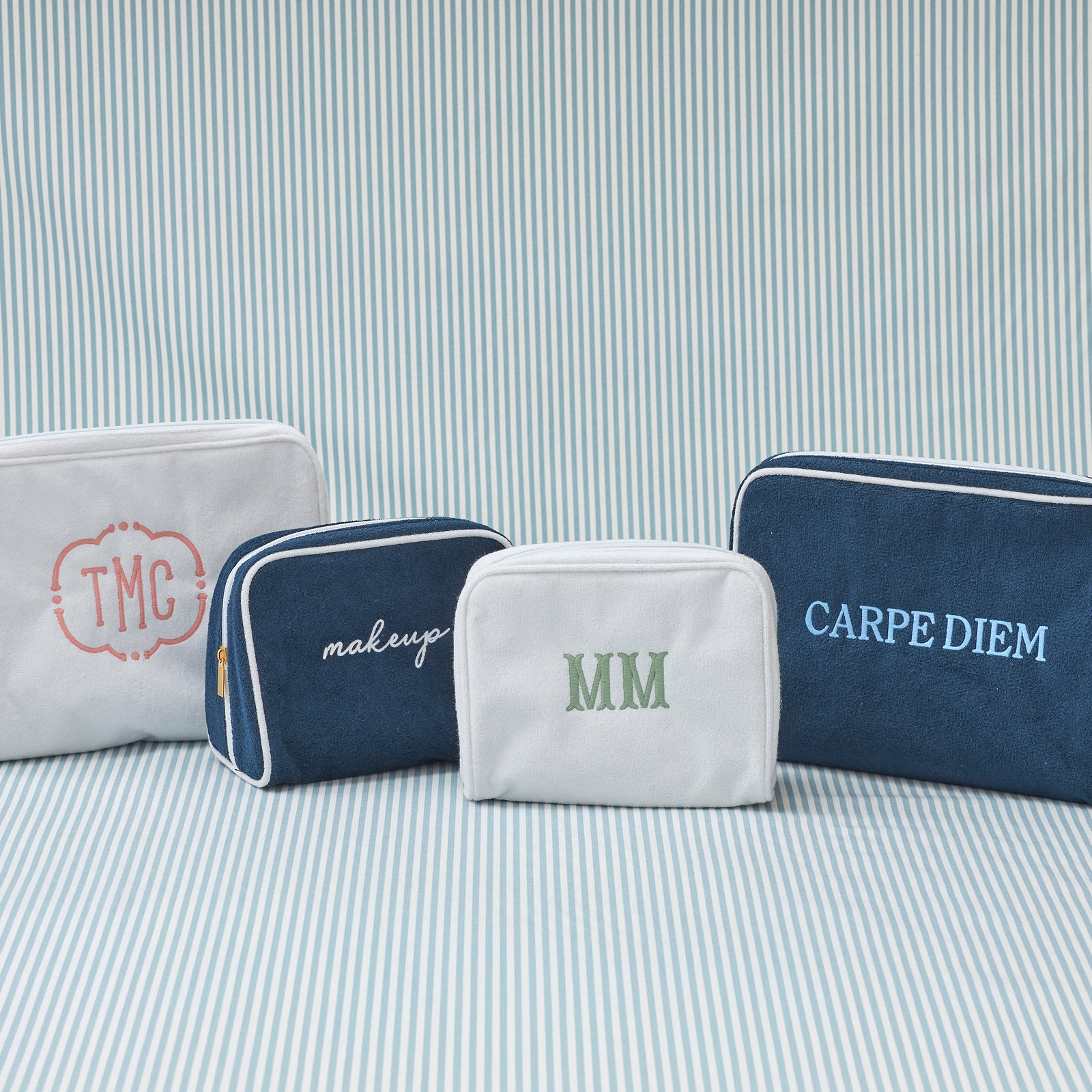 Large Signature Toiletry Bag in White with a sample monogram, laid flat.