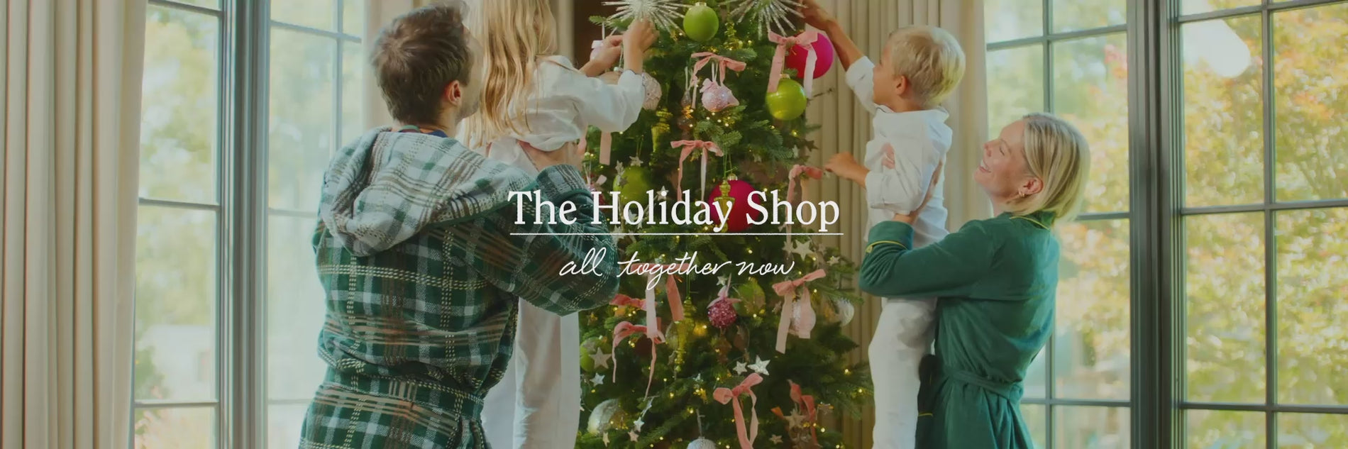 Video of a family of four wearing pajamas and robes sipping cocktails, reading, eating breakfast, and decorating the Christmas tree.